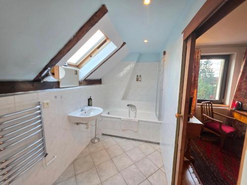 a bathroom with a sink and a bath tub at Dworek Adamski in Wałbrzych