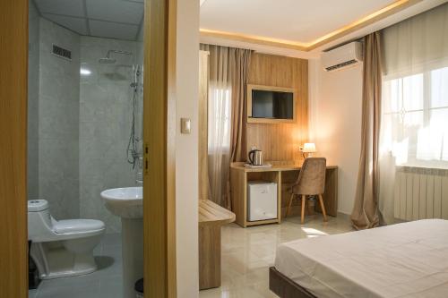 un bagno con letto, doccia e lavandino di Hotel Opera a Rouiba