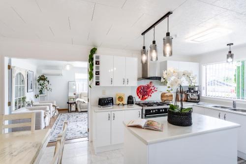 a kitchen with white cabinets and a counter top at Matahari Apartments and Villas in Upper Hutt