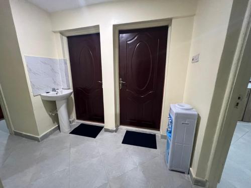 a bathroom with two brown doors and a sink at Gracious homes in Narok