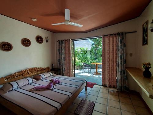 a bedroom with a large bed and a large window at Bermuda Beach Resort in Lagob
