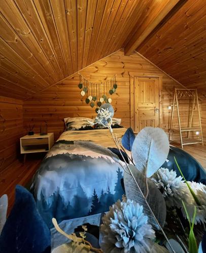 a bedroom with a bed in a log cabin at Cottage relaxant au bord de l'eau in Bourbourg