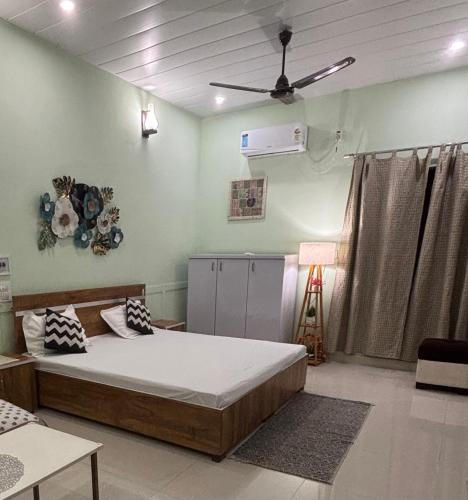 a bedroom with a bed and a ceiling fan at Peepal in Aranyaa Cottage Homestay Vrindavan in Vrindāvan