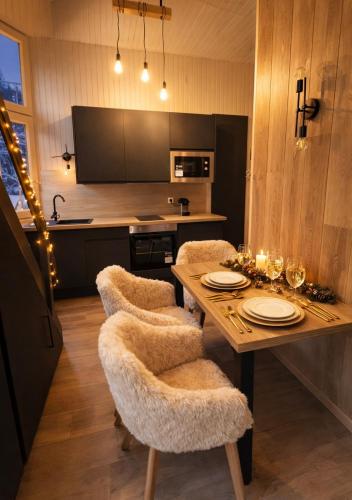 a dining room with a table and chairs with lights at Ma Montagne Chic 4 in La Bresse