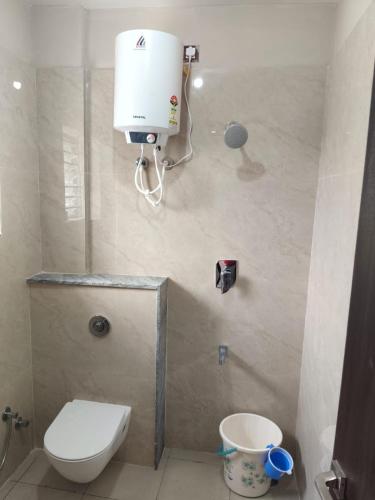 a bathroom with a toilet and a water heater at Nayana comforts in Nandigunda