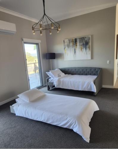 a bedroom with two beds and a couch at Riverbend Ranch Tamborine in Tamborine