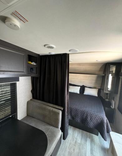 a bedroom in an rv with a bed and a couch at Glamping in Pueblo Magico Alamos Sonora in Álamos