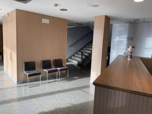 a lobby with a bar with chairs and a staircase at Blu Hotel Pamplona in Imárcoain