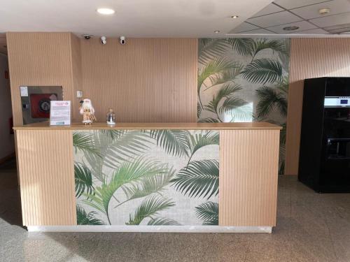 a lobby with a wall with a mural of palm trees at Blu Hotel Pamplona in Imárcoain