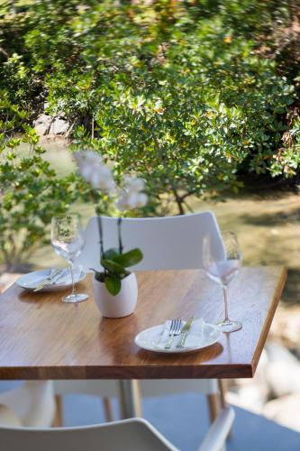 a wooden table with two wine glasses and a plant at Heart Hotel and Gallery Whitsundays in Airlie Beach