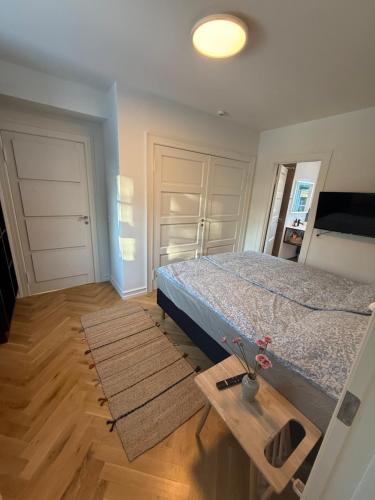 a bedroom with a bed and a wooden table at Ny & hyggelig moderne suite in Hvidovre