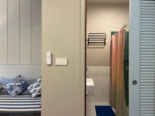 a bathroom with a bed and a shower at Nautical Home & Seashell House B&B in Khao Lak