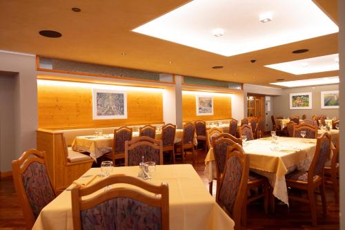a restaurant with tables and chairs in a room at Beohotel in San Lorenzo in Banale