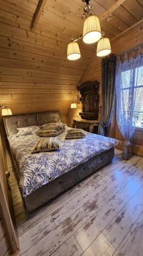 a bedroom with a bed in a log cabin at Domki góralskie z sauną i jacuzzi in Kościelisko