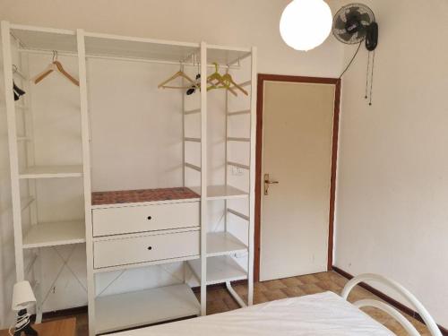 a bedroom with a white closet with shelves and a bed at Complesso Mosaico NON FORNISCE BIANCHERIA DA LETTO,NON FORNISCE ASCIUGAMANI NON FORNISCE PRODOTTI IN GENERE, appartamenti arredati come da foto, Per il Check in Agenzia Ferro Viale Francesco Petrarca 391 lido Adriano Ra in Lido Adriano