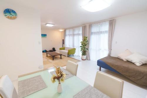 a living room with a bed and a table at The Kabira 川平湾に一番近いヴィラ 滞在中レンタカー無料 The closest private villa to Kabira Bay! Free car rental in Ishigaki Island