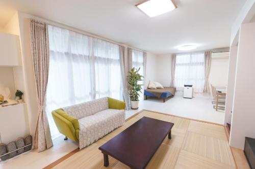 a living room with a couch and a table at The Kabira 川平湾に一番近いヴィラ 滞在中レンタカー無料 The closest private villa to Kabira Bay! Free car rental in Ishigaki Island