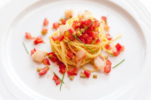 a plate of pasta with shrimp and pomegranate sauce at Hotel Miramonti in Bagno di Romagna