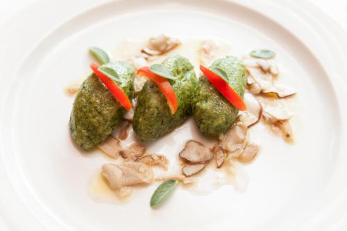 a white plate of food with vegetables and mushrooms at Hotel Miramonti in Bagno di Romagna
