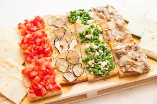 a plate with slices of pizza with vegetables on it at Hotel Miramonti in Bagno di Romagna