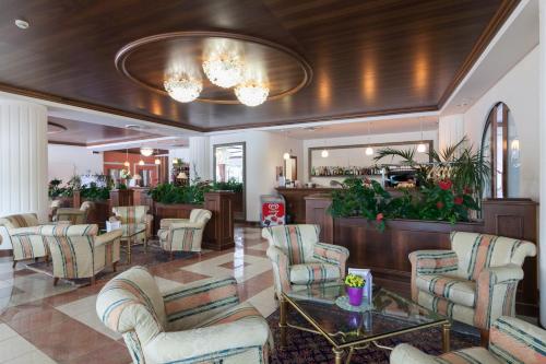 a lobby with chairs and tables and a bar at Hotel Miramonti in Bagno di Romagna