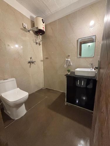 a bathroom with a toilet and a sink at Peepal in Aranyaa Cottage Homestay Vrindavan in Vrindāvan