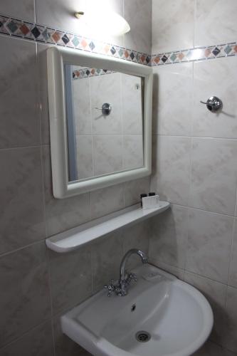 a bathroom with a sink and a mirror at Hotel Avra in Volos