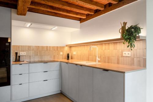 a kitchen with white cabinets and a sink at Boonackere Cottage in Oosterzele
