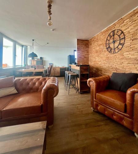 a living room with two couches and a brick wall at COAST HOUSE Havenquartier in Bremerhaven