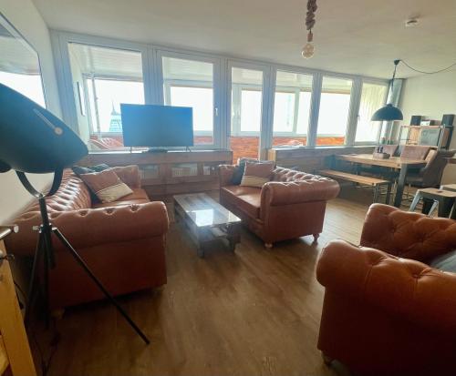 a living room with two couches and a television at COAST HOUSE Havenquartier in Bremerhaven