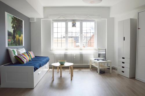 ein Wohnzimmer mit einem blauen Sofa und einem Tisch in der Unterkunft Flat Sympa next Grand Place in Brüssel