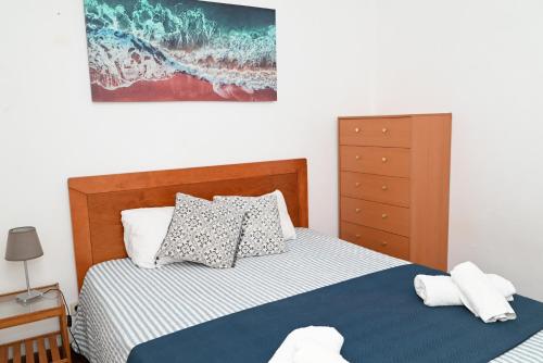 a bedroom with a bed and a dresser at FiloApartment in Peniche