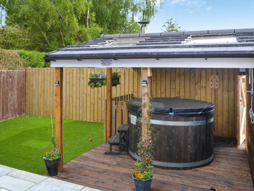 a hot tub on a deck next to a fence at Carolyn House in Ellington