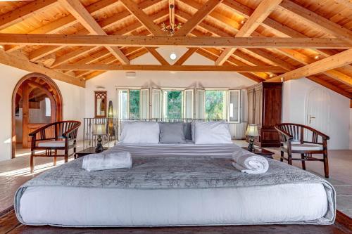 a large bed in a room with wooden ceilings at Eagle's Rest Villa in Kassiopi