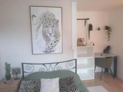 a bedroom with a picture of a leopard on the wall at l'auberge des trois lieux in Calais