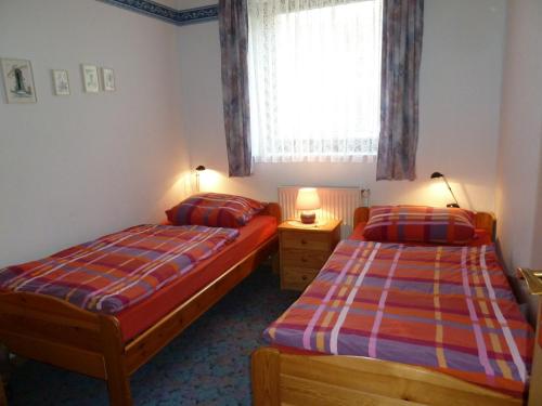 Duas camas num pequeno quarto com uma janela em Ferienhof Gruber em Wesseloh