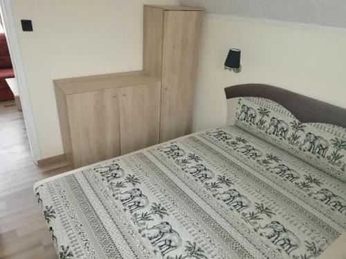 a bedroom with a bed with a black and white comforter at Vadrózsa Nyaraló in Balatongyörök