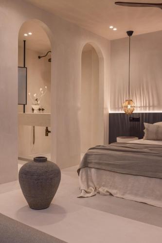 a bedroom with a bed and a vase in the middle at Kantouni Lindos ELEGANT APARTMENT in Lindos