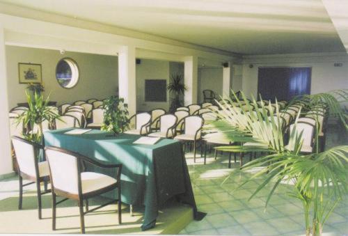 einen Konferenzraum mit einem grünen Tisch und Stühlen in der Unterkunft Villa Dei Principi Hotel in Terracina