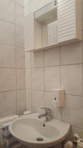 a white bathroom with a sink and a mirror at Guesthouse Bosankic in Makarska