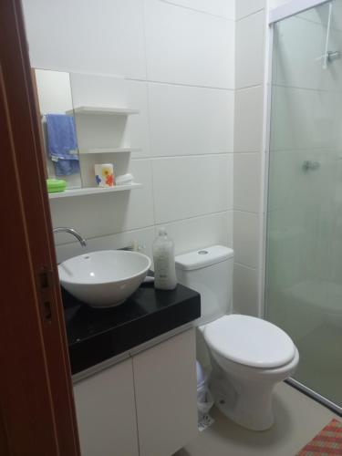 a bathroom with a toilet and a sink and a shower at Paraiso Ponta de Campina in Cabedelo
