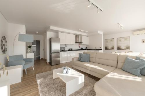 a white living room with a couch and a kitchen at Silver Coast Haven in Coto
