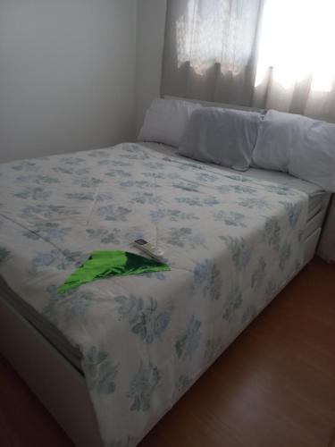 a bed with a blue and white bedspread with a green leaf on it at Paraiso Ponta de Campina in Cabedelo
