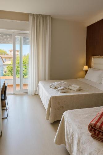 a hotel room with two beds and a balcony at Residence Elisabetta in Cesenatico