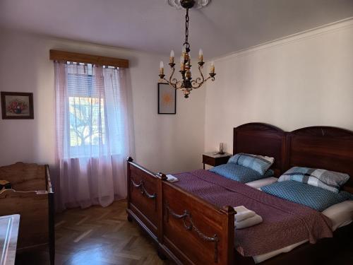a bedroom with a bed and a chandelier at Ferienwohnung Veljanovski Haus der Sonne in Blaufelden