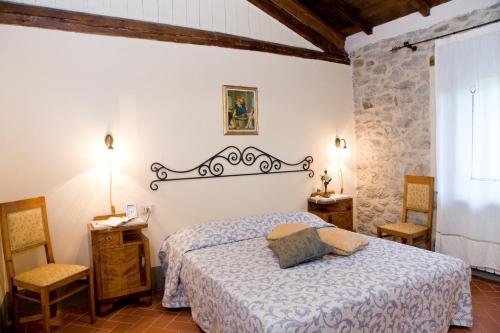 a bedroom with a bed and two chairs at La Casetta di Giovanni in Pratovecchio