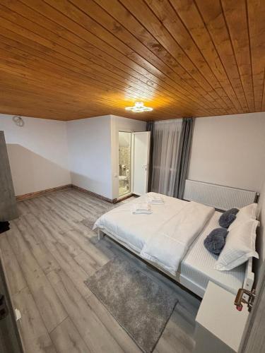 a bedroom with a large bed with a wooden ceiling at La Moieciu pe Deal in Moieciu de Jos