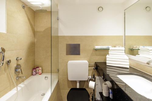 a bathroom with a tub and a sink and a shower at Red Fox Apartment in Garmisch-Partenkirchen