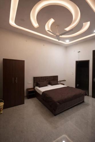 a bedroom with a large bed with a large ceiling at Vrindavaneshwari Residence in Vrindāvan