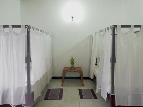 a dressing room with white curtains and a table at 2in1 Kandy Hostel in Kandy
